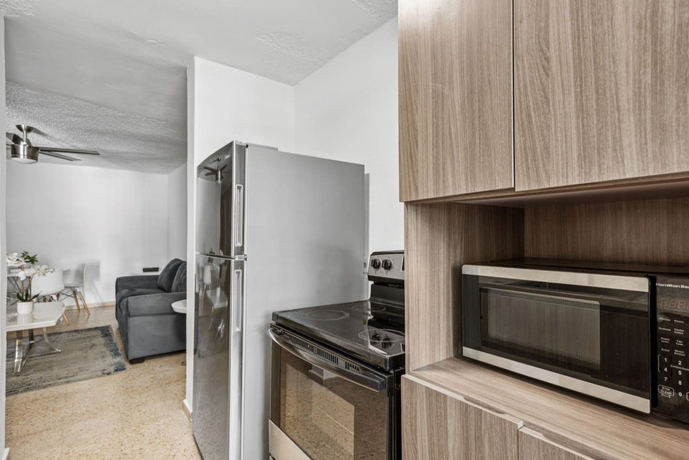 Een moderne keuken met een ingebouwde magnetron, oven en koelkast.