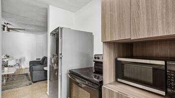 Een moderne keuken met een ingebouwde magnetron, oven en koelkast.