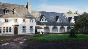 A building with a central courtyard, arched windows, and a tower. - Les Gîtes de la Morinière - Brocéliande: The Little House on the Prairie (Neant sur Yvel)
