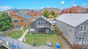 Un quartier résidentiel comprenant une maison en bois, un petit jardin et une jetée qui s’avance sur une étendue d’eau.
