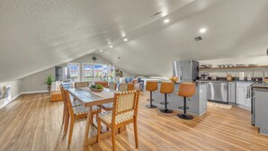 Un loft spacieux comprenant un coin repas, une cuisine et un espace salon.