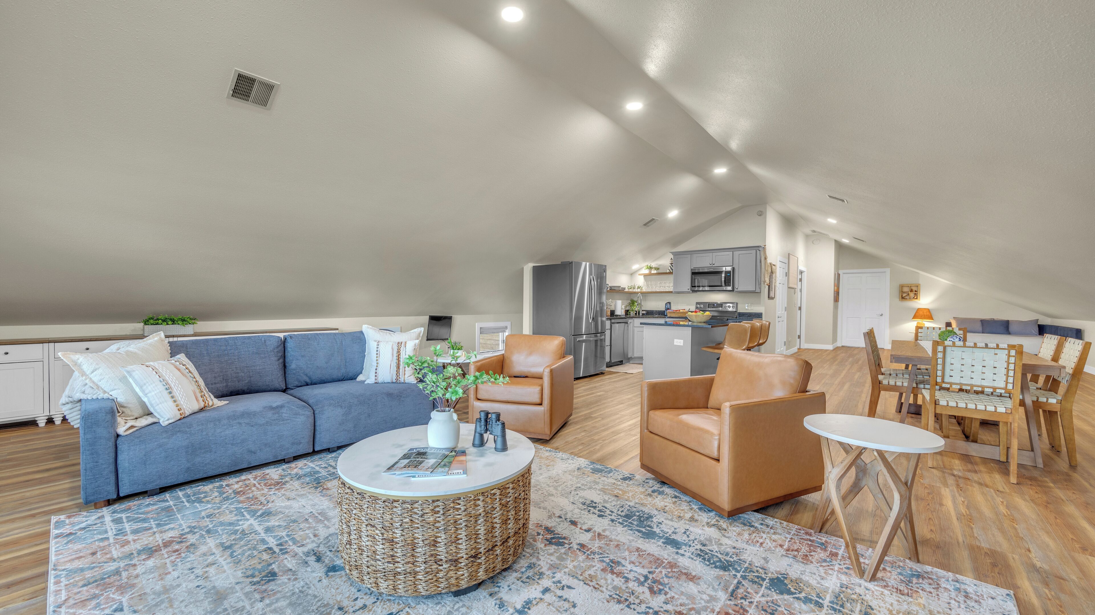 A spacious loft with a living area, kitchen, and dining space.