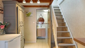 Een smalle gang met een trap naar een badkamer.