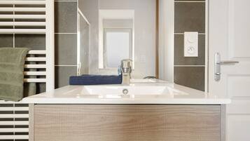 A bathroom with a white sink, a mirror, and a towel rack.