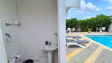 A compact bathroom with a toilet, sink, and a small trash bin.