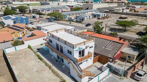 Un immeuble de deux étages sur lequel on peut lire l’inscription « Ocean Breeze Apartments ». Il a un toit plat, un balcon au deuxième étage et un parking à l’avant.