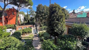 A courtyard with a pathway, surrounded by trees and buildings. - Bohémien Rome (Roma)