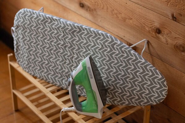 An ironing board with a patterned cloth and an iron on it.