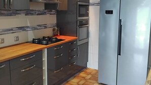A modern kitchen with grey cabinets, a stainless steel refrigerator, a built-in oven, and a gas stove. - House 115m² with swimming pool, 20 min from Bordeaux center Tram 500m. (Eysines)