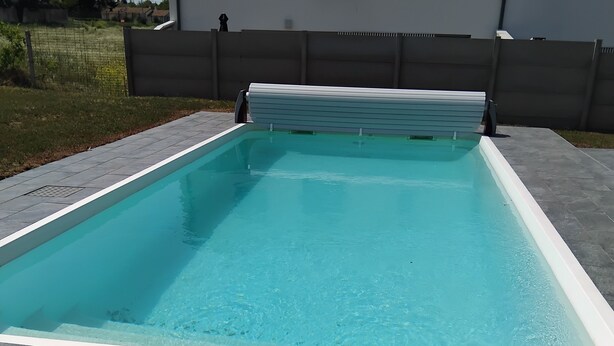 A rectangular swimming pool with a white edge, surrounded by grey tiles. - House 115m² with swimming pool, 20 min from Bordeaux center Tram 500m. (Eysines)