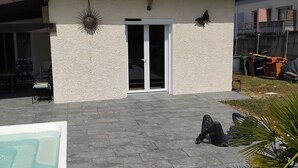 A house with a tiled roof, a white exterior wall, a glass door, and a patio area with a pool. - House 115m² with swimming pool, 20 min from Bordeaux center Tram 500m. (Eysines)