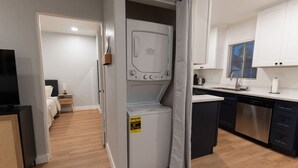 A compact kitchen with a dishwasher, a built-in oven, and a small dining area.