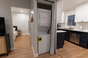A compact kitchen with a dishwasher, a built-in oven, and a small dining area. - Modern Hideaway in North Park - 3941 (San Diego)