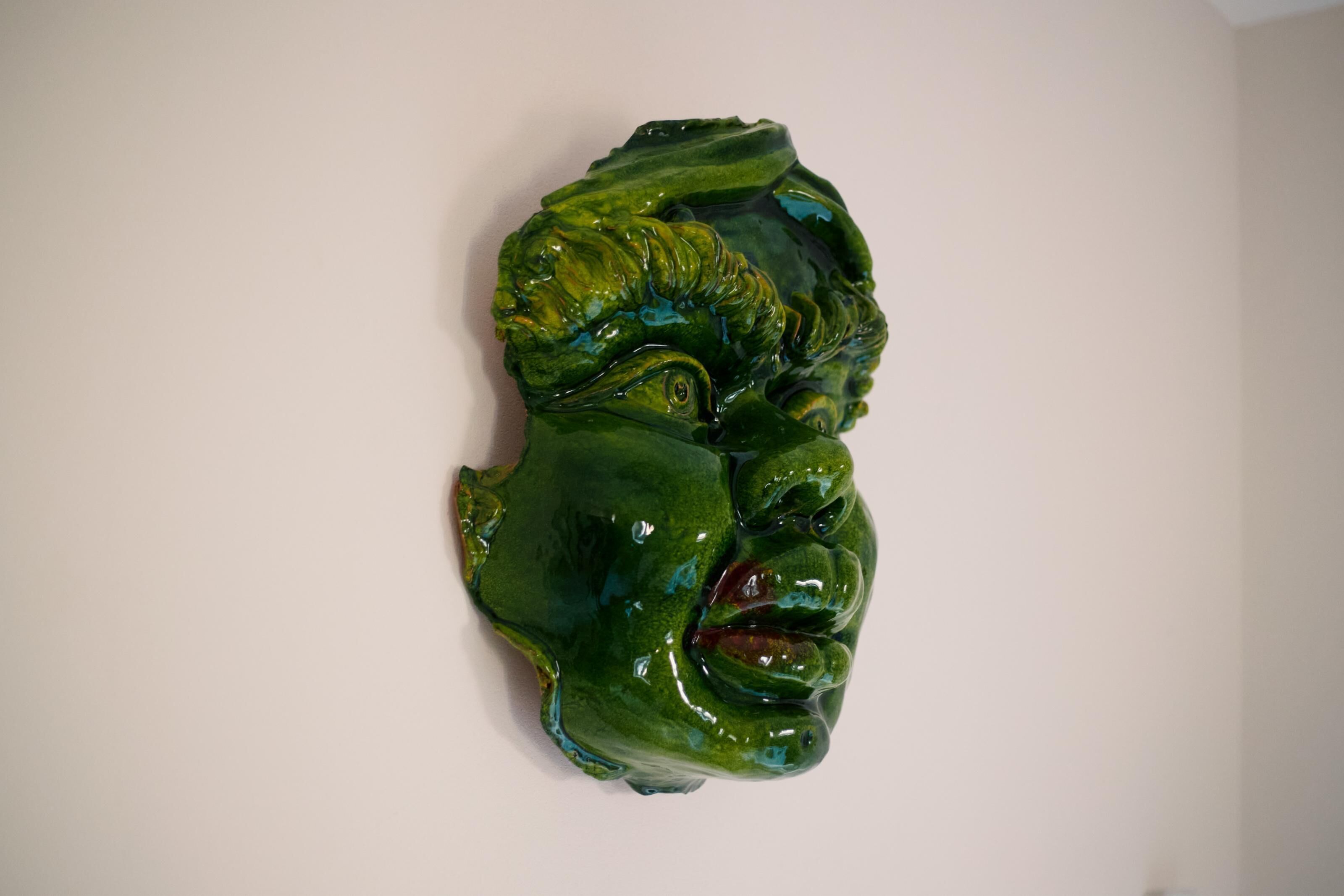 Una escultura sobre una pared lisa.