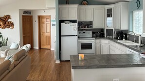 A modern kitchen with white cabinets, a built-in oven, and a coffee maker. - Surfers Perch: Amazing Pacific Ocean Views (Tillamook)