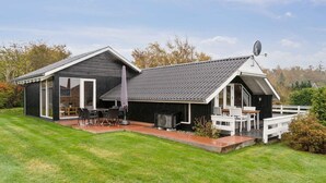 Ett modernt hus med en uteplats, en matplats och en satellitantenn.