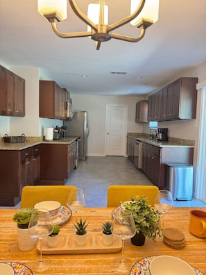Una cocina moderna con armarios de madera oscura, electrodomésticos de acero inoxidable y una isla central con asientos.