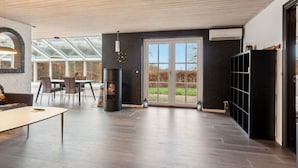 Ein modernes Interieur mit Kamin, Essbereich und großem Fenster.