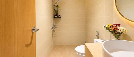 Une salle de bain avec douche, toilettes et lavabo.