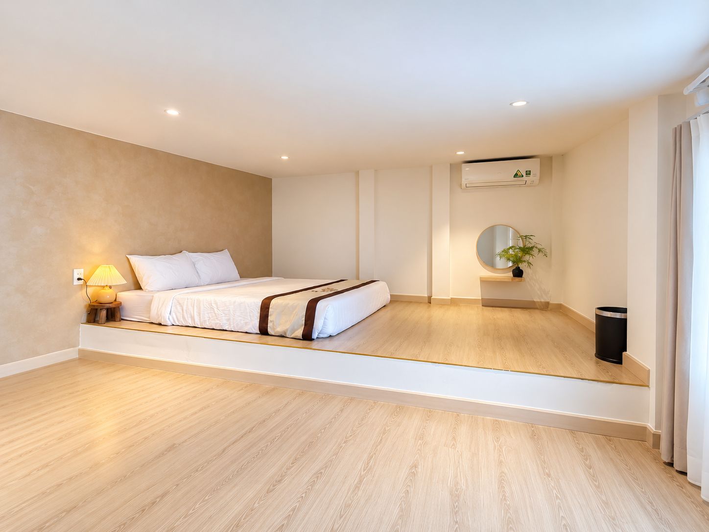 Une chambre à coucher moderne avec un lit, une lampe de chevet et une petite plante posée sur une étagère.