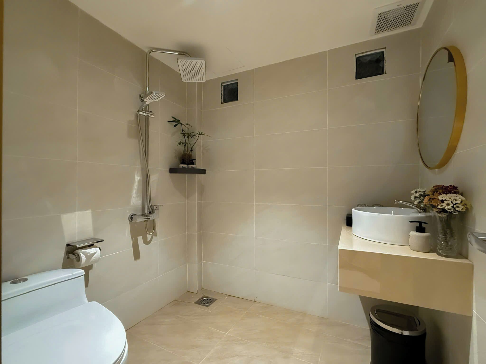 A modern bathroom with a shower, toilet, and sink.