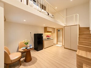 A modern apartment with a living area, kitchen, and a staircase leading to a loft bedroom. - Chinchu Stay  (Ho Chi Minh City)
