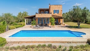 Une maison à deux étages avec une piscine à l’avant.