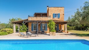 Ein zweistöckiges Haus mit Schwimmbecken davor.