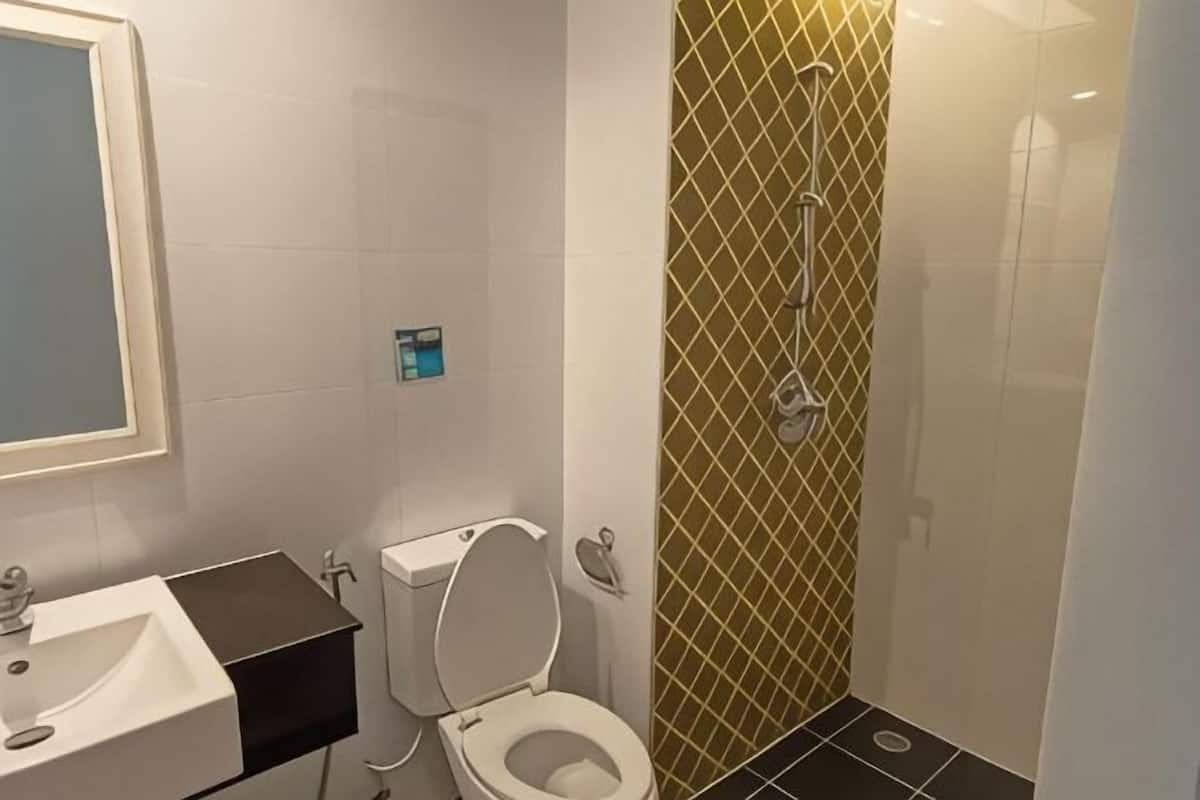 Une salle de bain avec des toilettes, un lavabo et une douche.