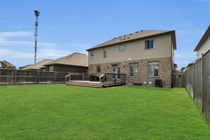 Una casa de dos pisos con patio trasero.
