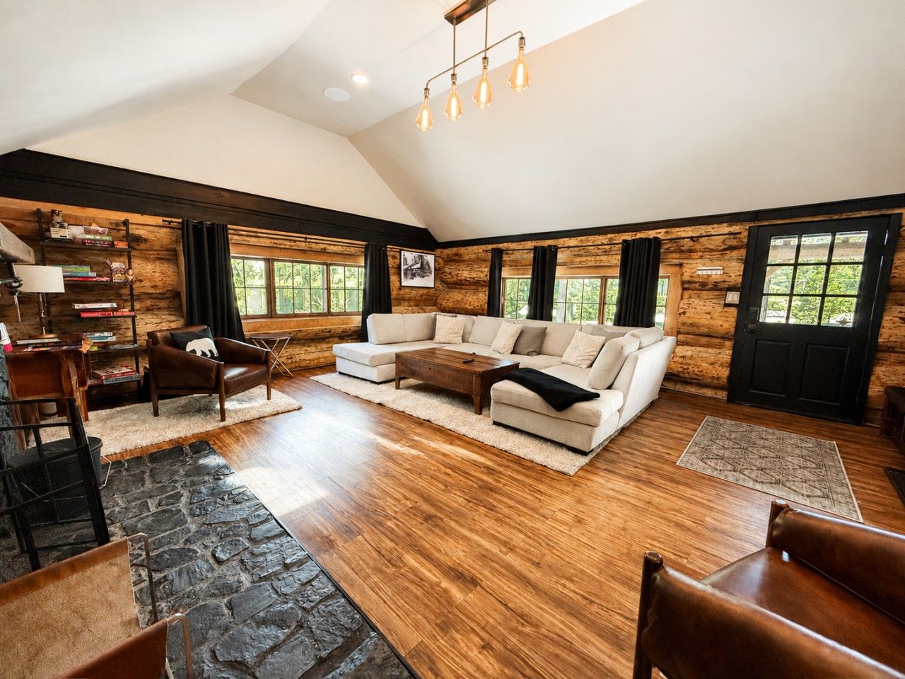 A spacious living room with a large sectional sofa, a coffee table, and a fireplace.