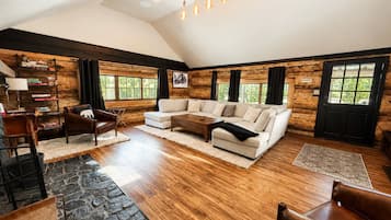 A spacious living room with a large sectional sofa, a coffee table, and a fireplace.