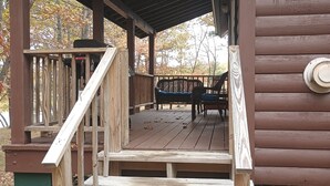 A wooden deck with a staircase leading to a covered porch area. - Rustic  cabin  in Lincoln Maine  (Lincoln)
