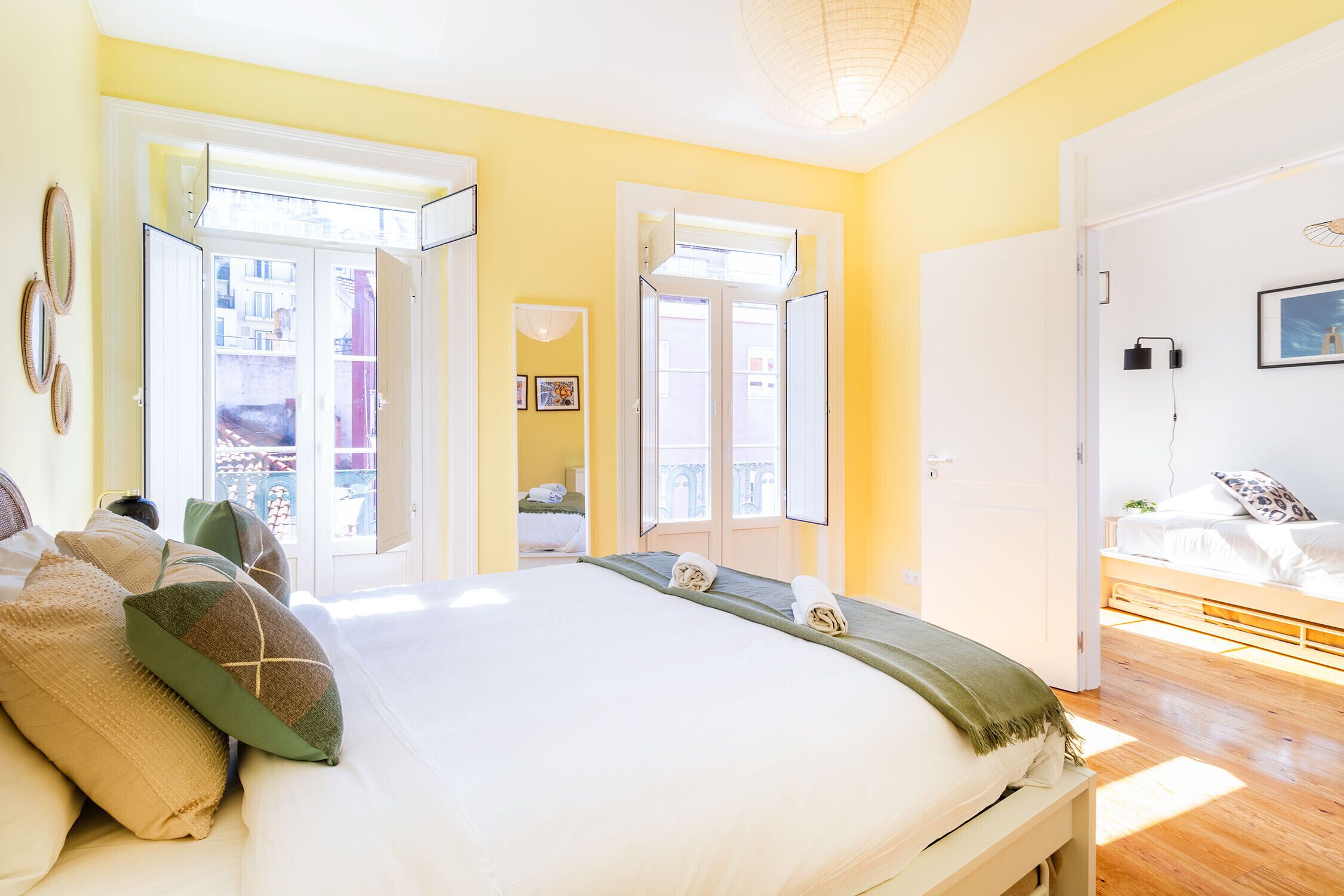 A bedroom with a bed, pillows, a bedside table, and a window.