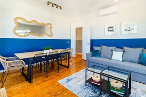 Una sala de estar moderna con comedor, un sofá y una mesa de centro.