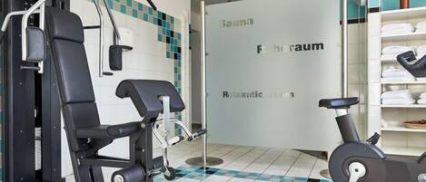 Un gimnasio con equipamiento de ejercicio, sauna y zona de recepción.