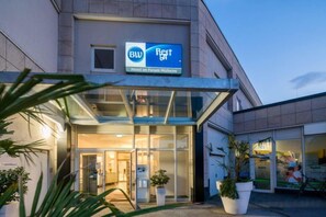 A hotel entrance with a glass facade, signage for 'BW Hotel In Forum Mühlheim,' and potted plants. - Best Western Hotel Im Forum Muelheim (Mulheim an der Ruhr)