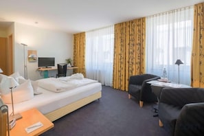 A hotel room with a bed, a desk, a chair, a TV, and curtains. - Best Western Hotel Im Forum Muelheim (Mulheim an der Ruhr)