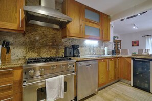 A kitchen with wooden cabinets, a stainless steel range, a dishwasher, and a coffee maker.