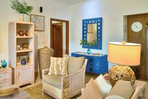 A living room with a sofa, a blue dresser, a large mirror, and a clock on the wall. - 3BR~Beach~ Escape @Terrenas+Pool +Family+Balcones (El Limón)