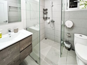 A modern bathroom with a glass shower enclosure, a white sink, and a toilet. - "The Good Life" at PGA Ocean’s 4 /GolfView/4BR Sleeps 9/Private Pool/5 Min Beach (San Pedro de Macoris)