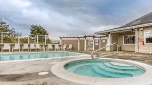Un espace piscine avec des chaises longues et un coin salon abrité.