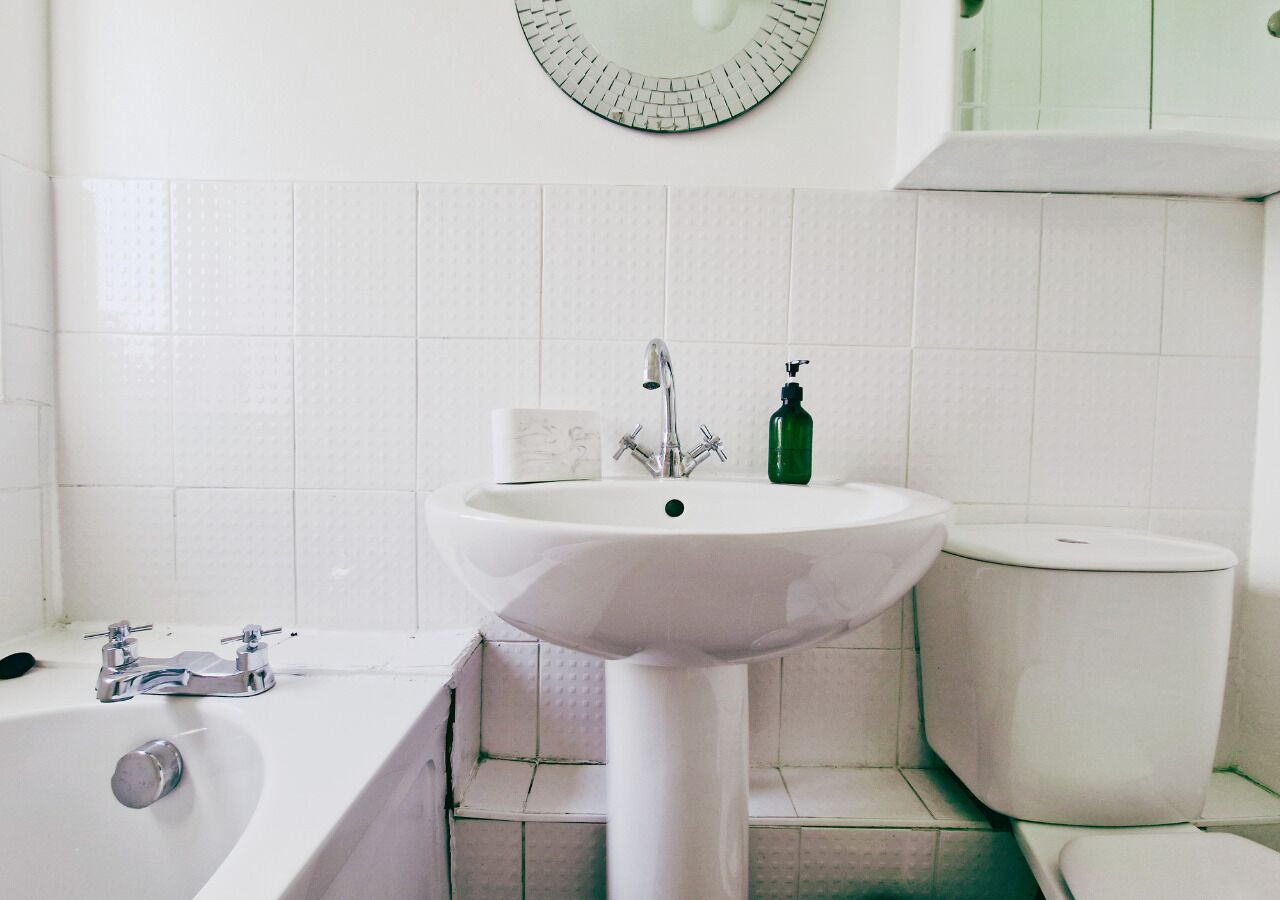 Une salle de bain avec un lavabo blanc, une baignoire et des toilettes.
