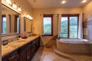 A bathroom with two sinks, a large bathtub, and a window with curtains. - Luxury Mountain Cabin Amazing Look out Views (Sevierville)