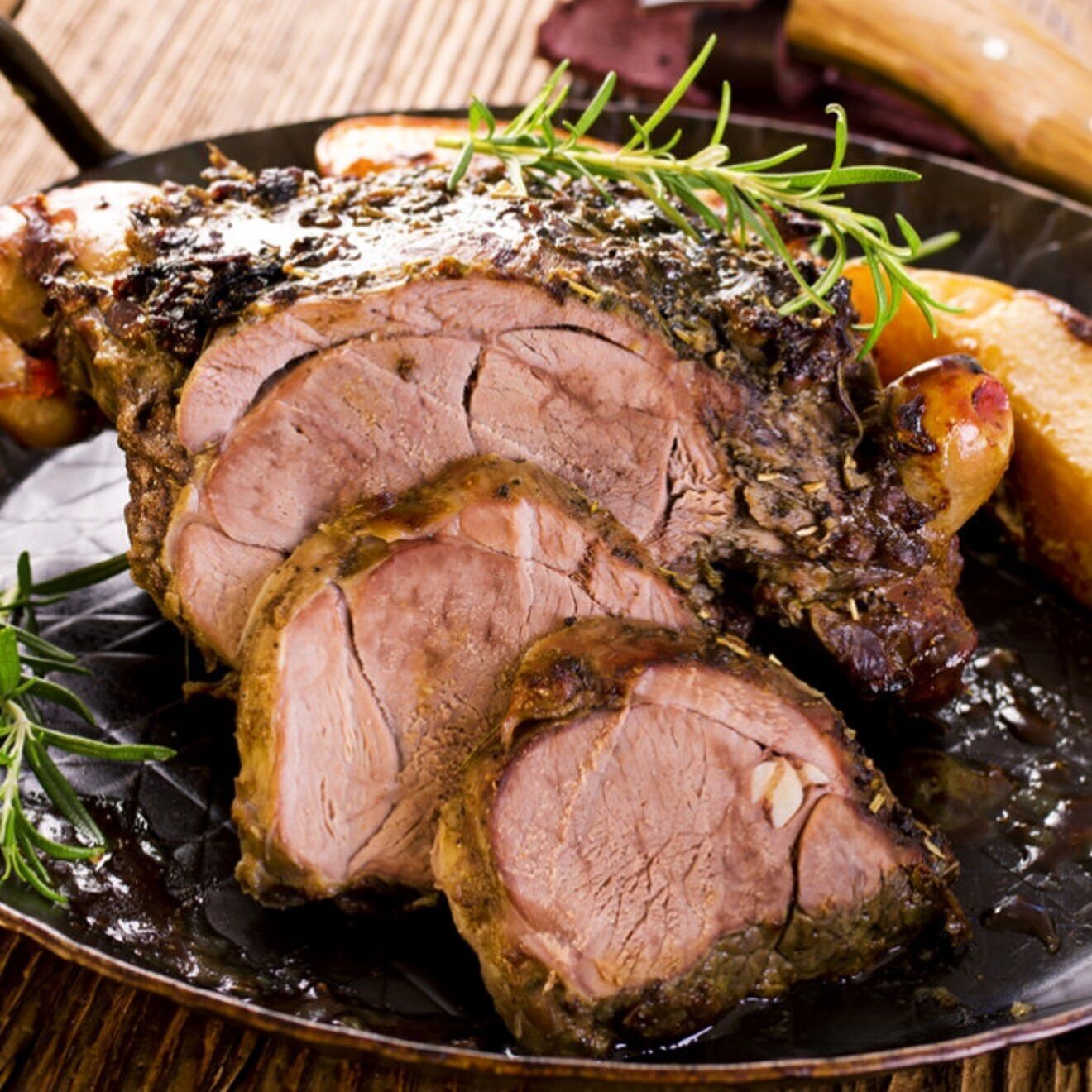 A roasted beef dish with rosemary garnish.