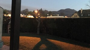 A view of a rural landscape with a house, a lamp post, and a hedge. - Marjolaine Bed and Breakfast on the ground floor (Lourdes)