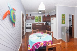 A compact kitchen with wooden cabinets, a white refrigerator, and a water dispenser.