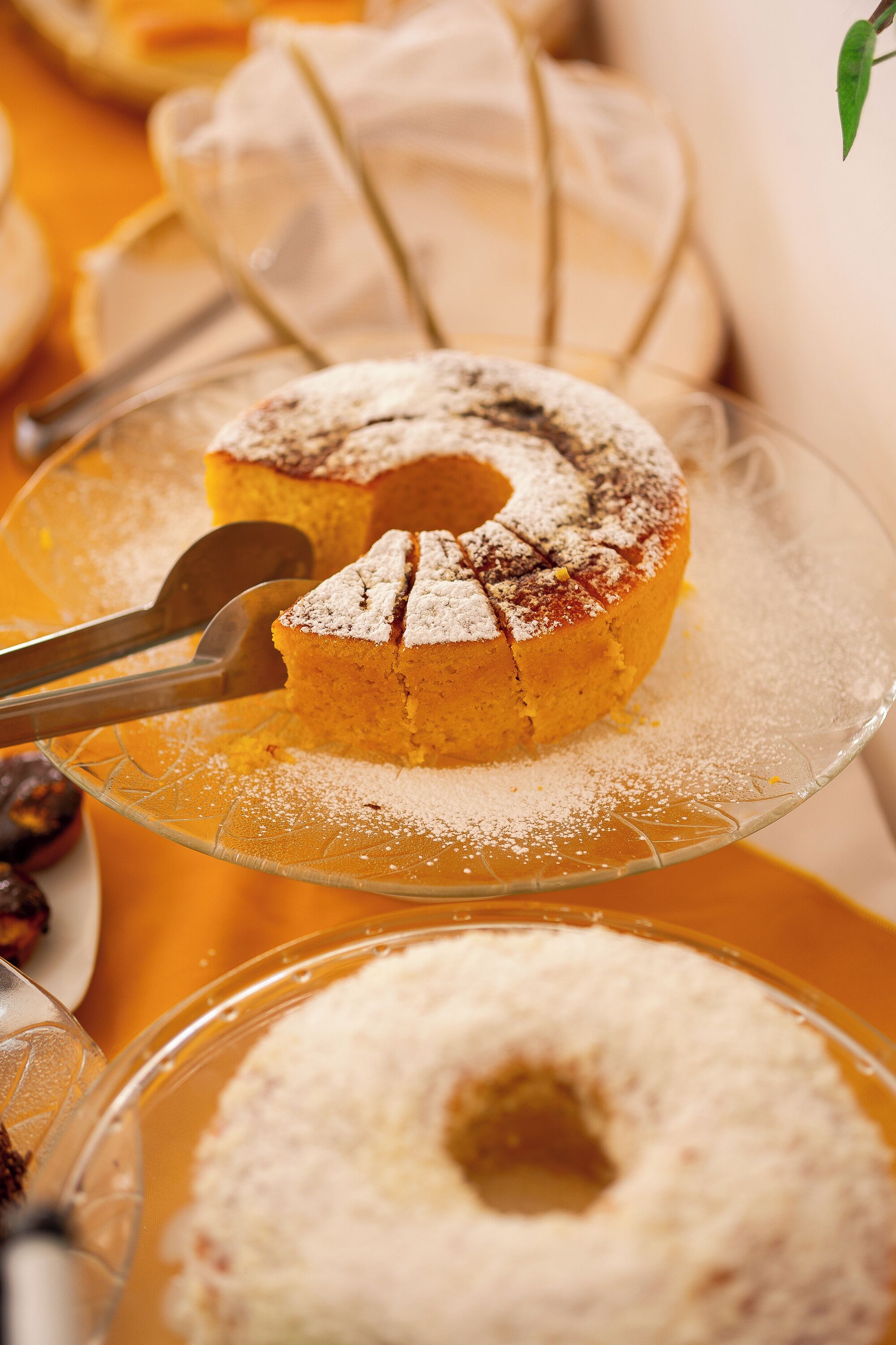 Un gâteau sur une assiette en verre, saupoudré de sucre glace.