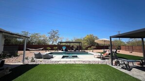 A backyard with a swimming pool, artificial grass, and outdoor furniture. - Updated! - The Stratford Resort: Pool & Spa (Tucson)