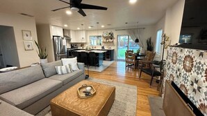 A modern living room with a sofa, coffee table, and a dining area with chairs and a table. - Updated! - The Stratford Resort: Pool & Spa (Tucson)